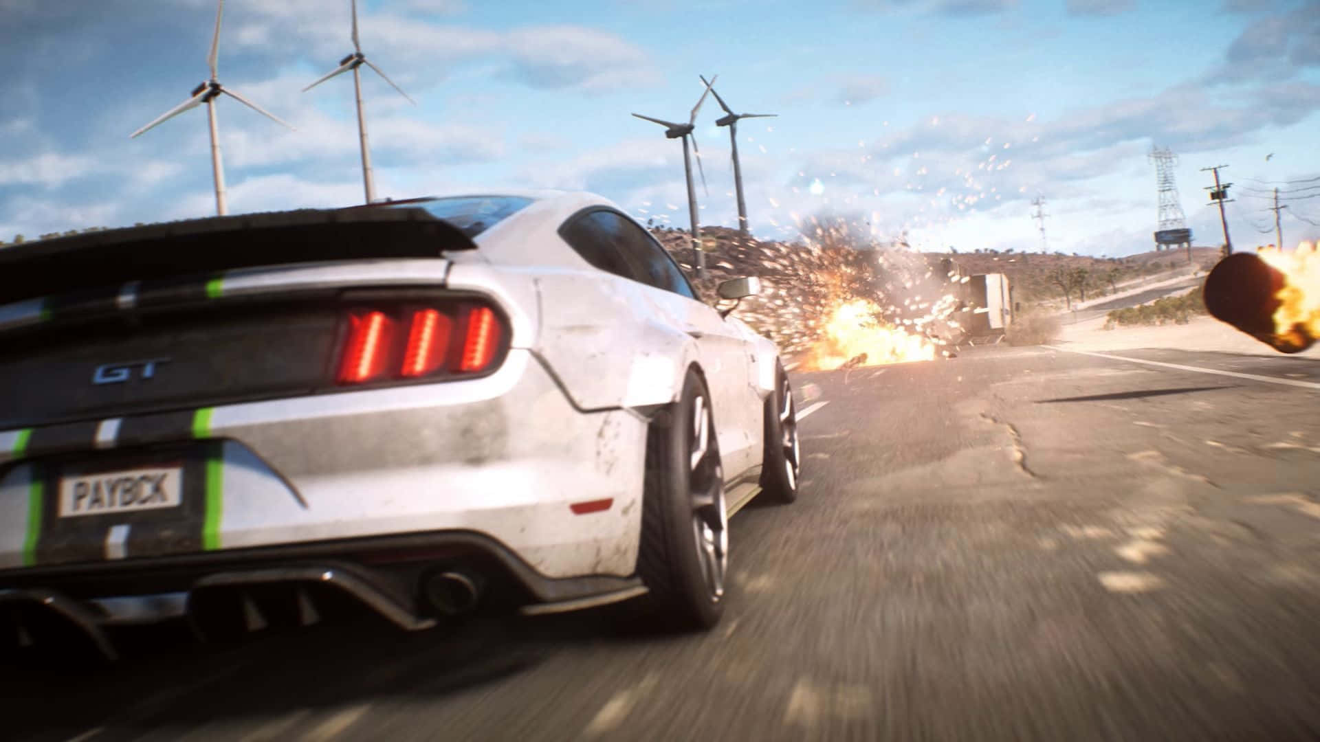 在《Need for Speed Payback》中壓倒你的對手 壁紙 — 一輛白色Mustang GT在塵土飛揚的道路上奔馳，背景有爆炸和風力發電機，天空湛藍。
