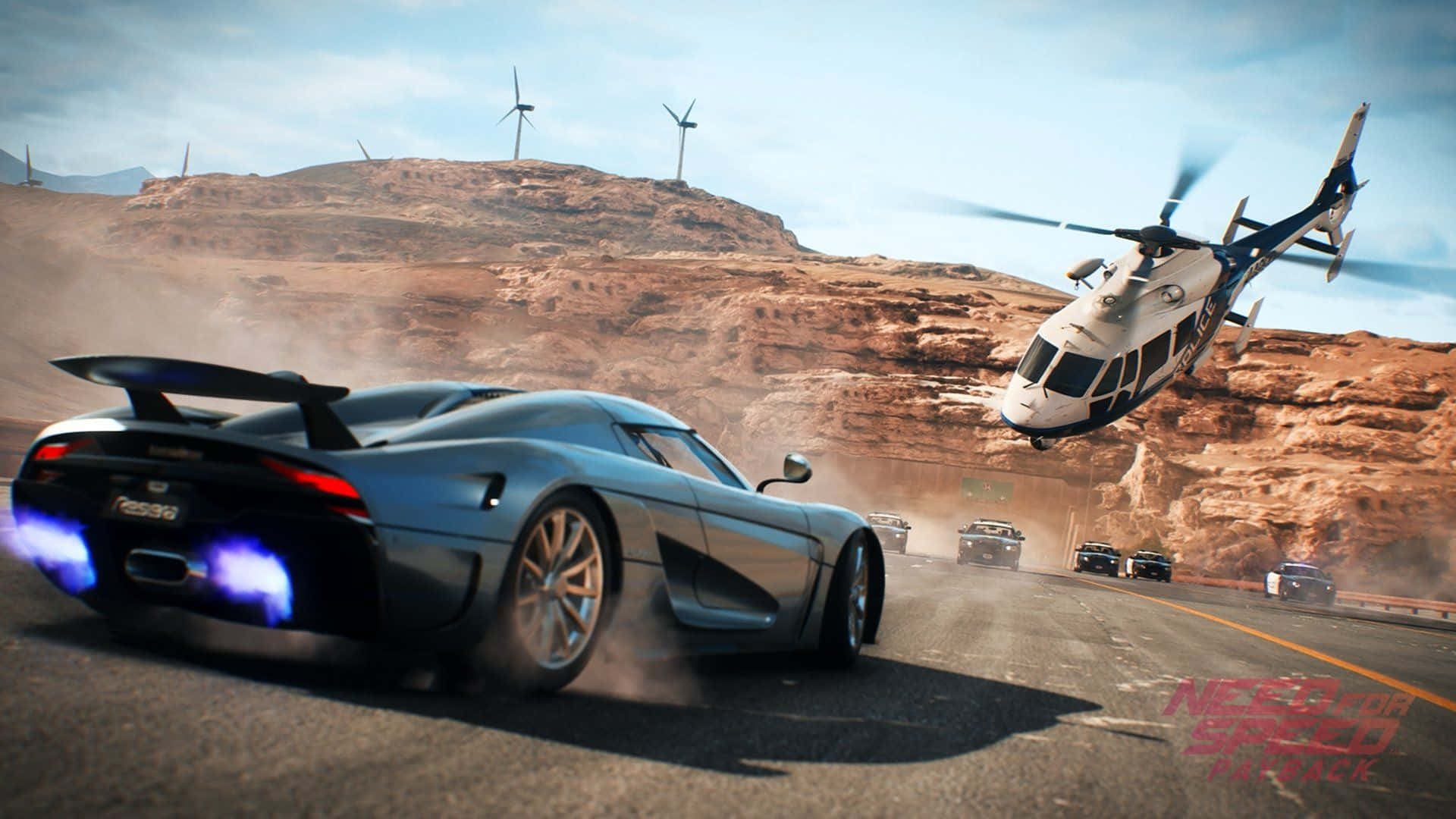 在《Need for Speed Payback》中衝向終點線 壁紙 — 一輛時尚的銀色跑車帶有發光藍色排氣管，在沙漠公路上疾馳，直升機在風力渦輪機附近飛過。