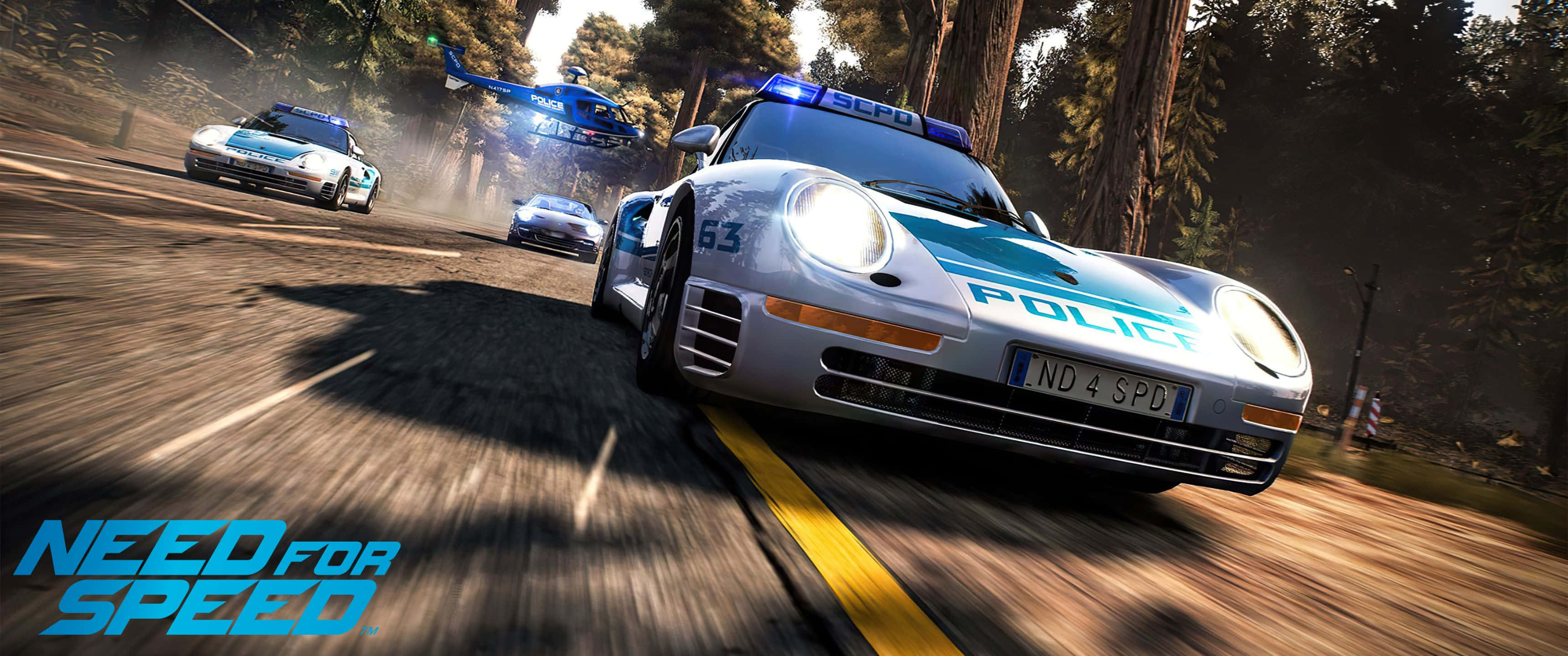 在《Need For Speed》中全力加速，突破極限 壁紙 — 一輛警用跑車在森林道路上高速行駛，直升機和其他車輛在高速賽車場景中追逐。