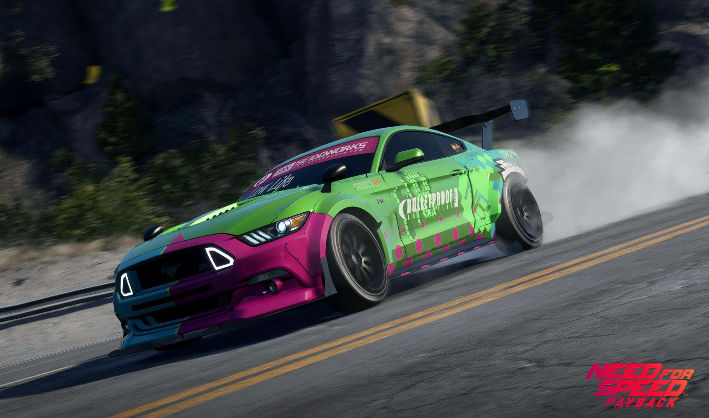 在《Need For Speed Payback》中奔向榮耀 壁紙 — 一輛充滿活力的綠色和粉紅色漂移車在山路上冒煙輪胎，出現在電子遊戲場景中。