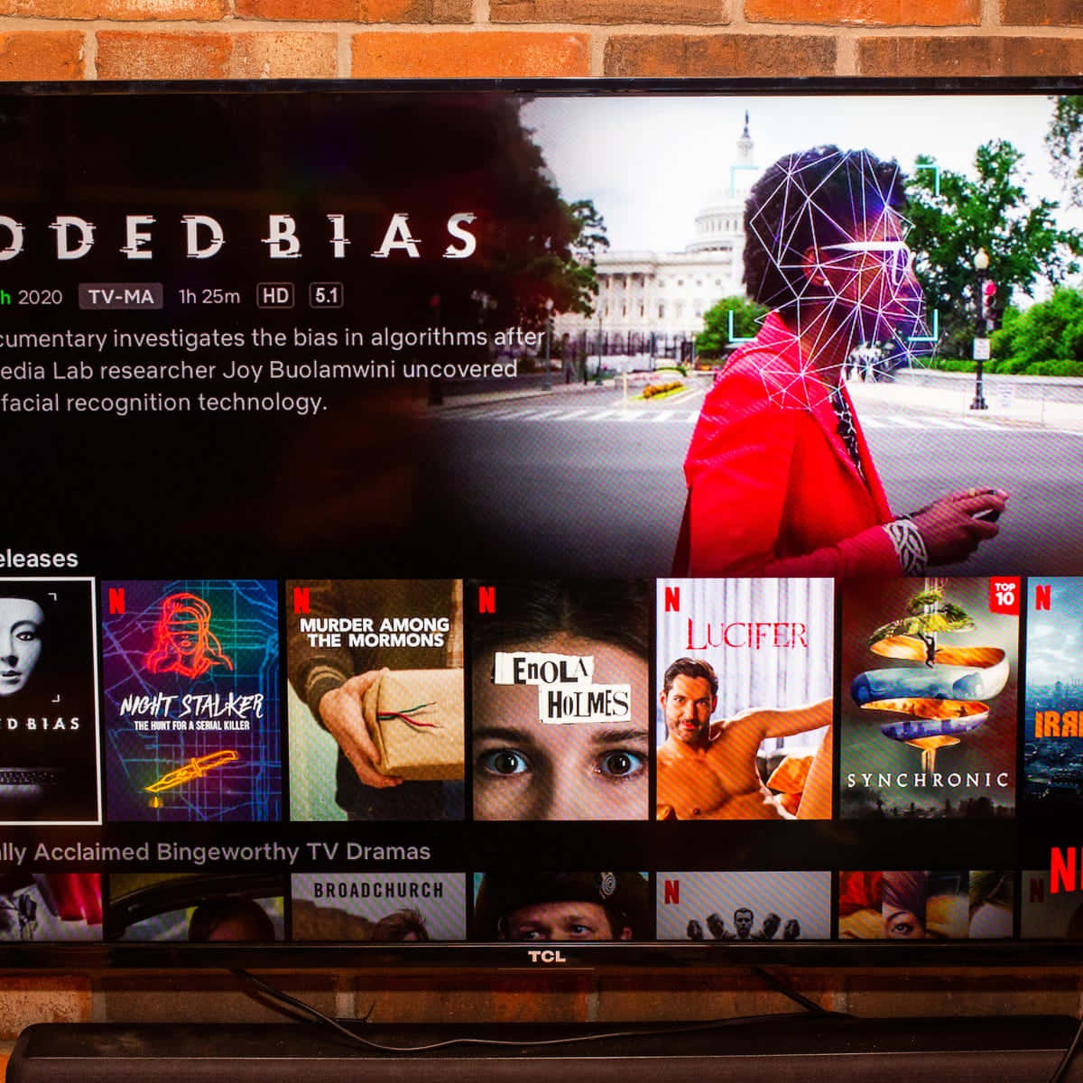 電視屏幕顯示Netflix紀錄片，關於演算法偏見，帶有面部識別疊加層。