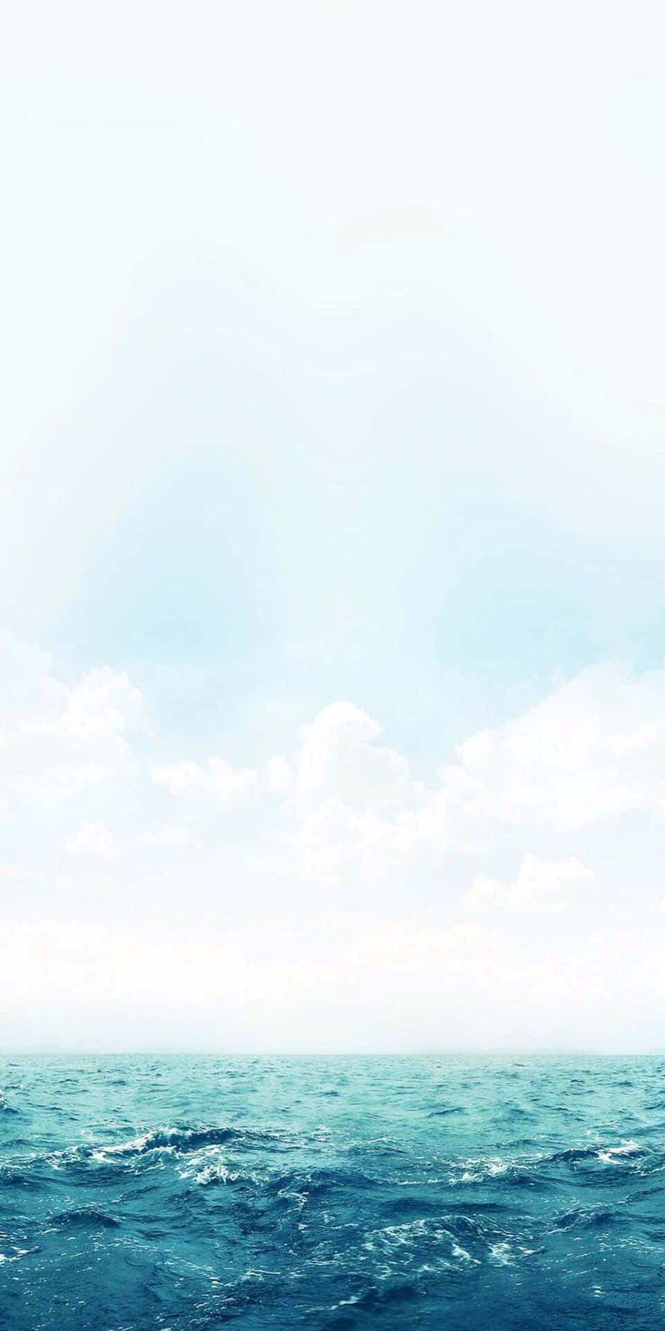 明亮的藍天下，蓬鬆的白雲和寧靜的海洋波浪。