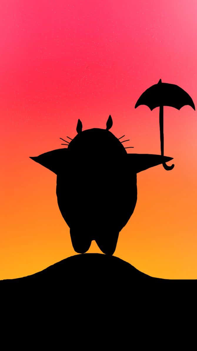 my neighbor totoro 桌布 壁紙 — 在 vibrant 的粉紅和橙色日落天空背景下，龍貓在山丘上撐著雨傘的剪影。