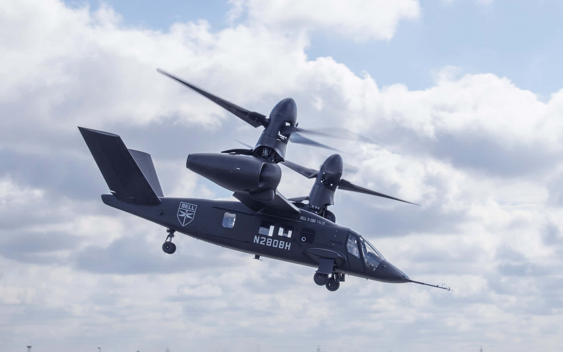 黑色Bell V-280 Valor傾轉旋翼機飛行中，起落架已放下。