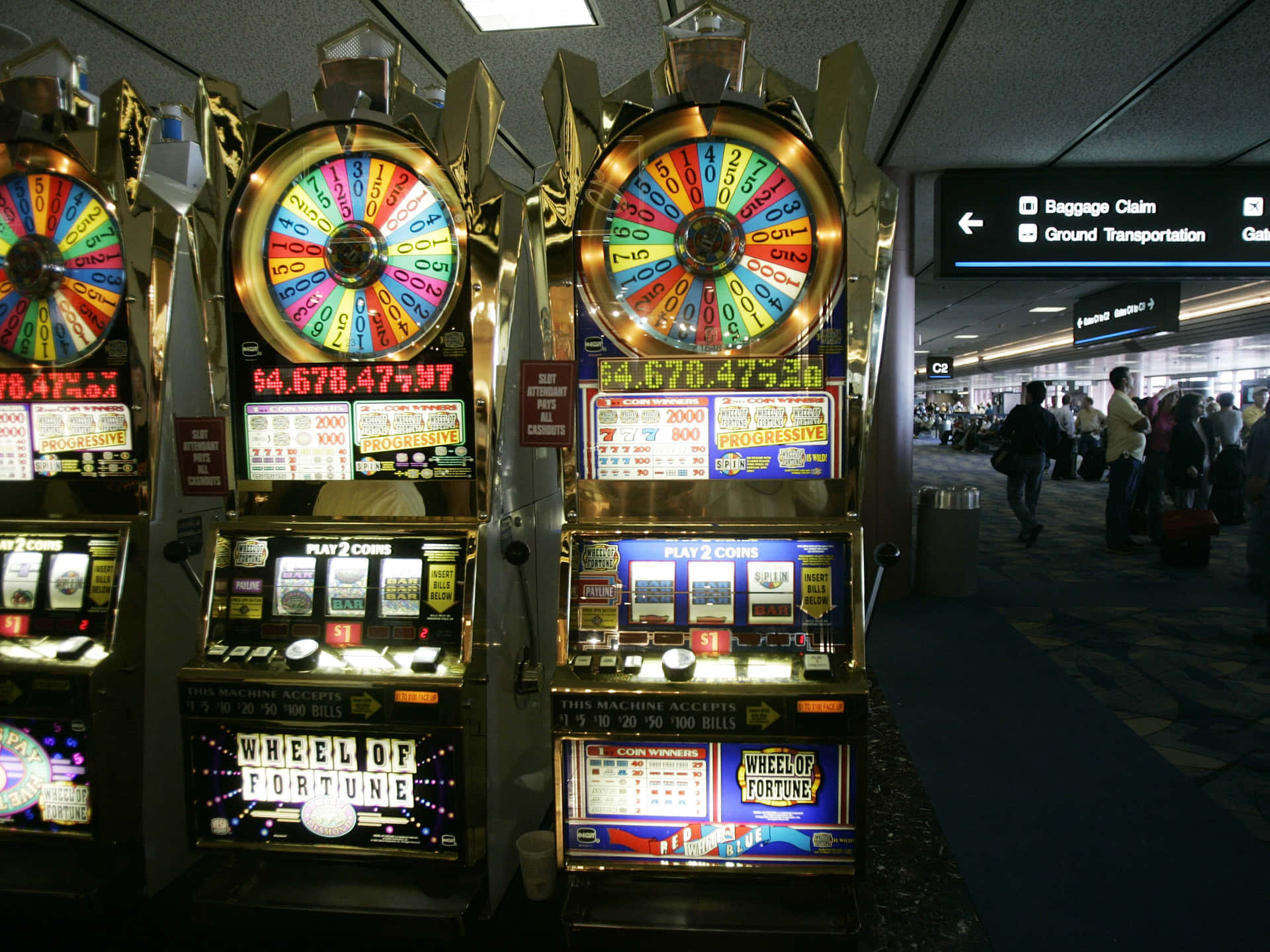 在繁忙的機場中發光的 Wheel of Fortune 老虎機，旅客們走過。