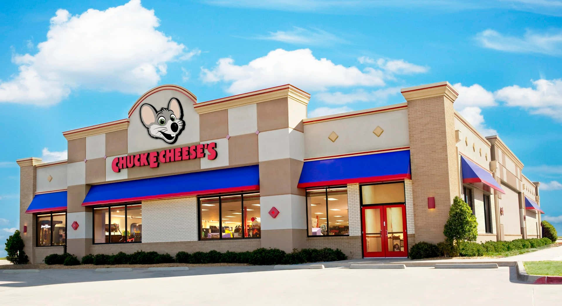 Chuck E Cheese's餐廳，設有藍色遮陽篷和紅色門，位於陽光明媚的天空下。