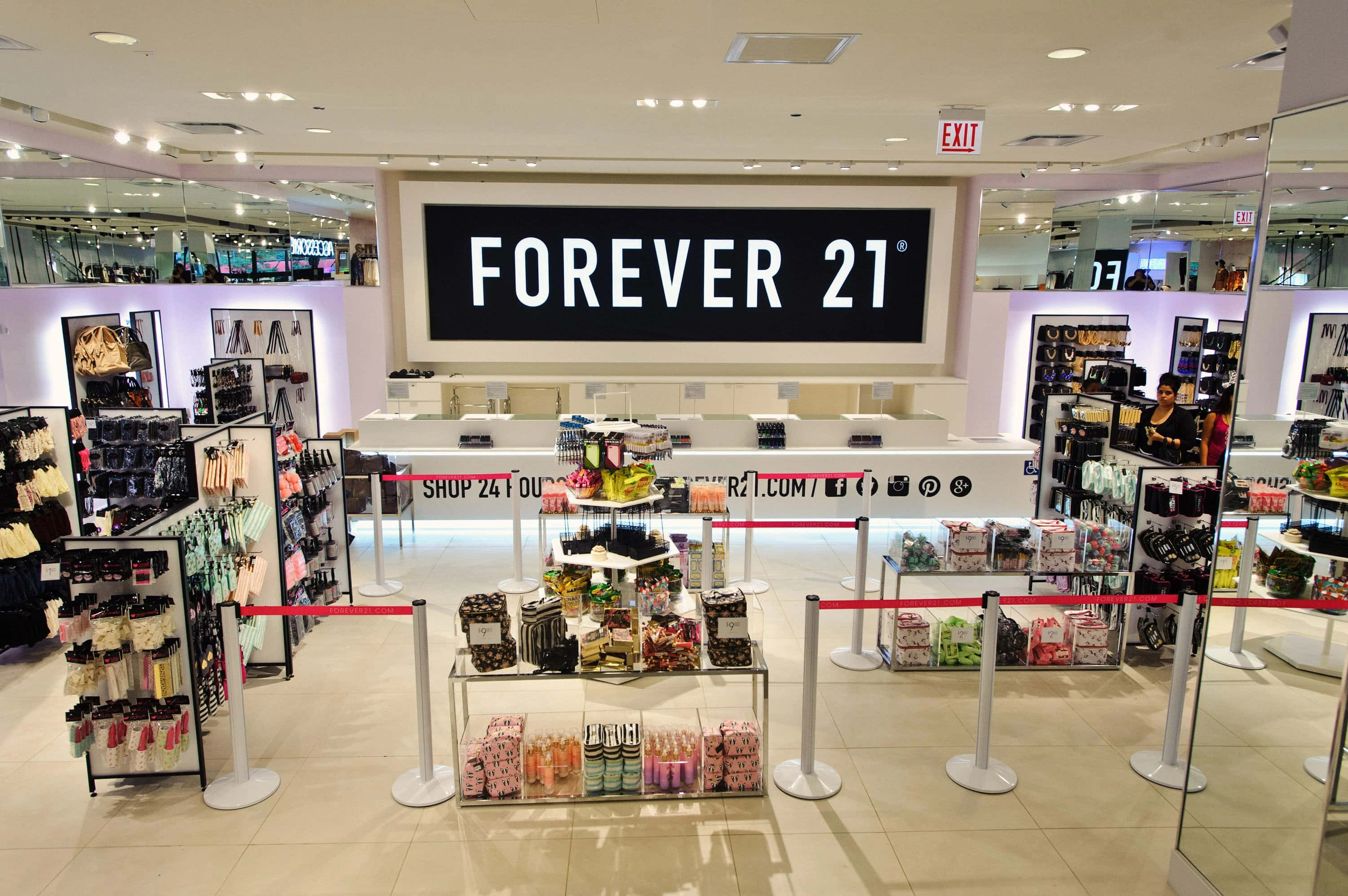 在Forever 21以最新時尚風格保持永遠時尚 壁紙 — 明亮的Forever 21店內，設有商品展示和紅色欄柱，上方有大型品牌標誌。