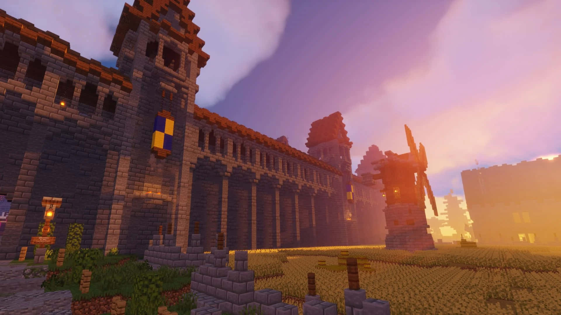 Minecraft Server 桌布 壁紙 — 在Minecraft世界中，一座像素化的中世紀城堡和風車矗立在紫色日落天空下。