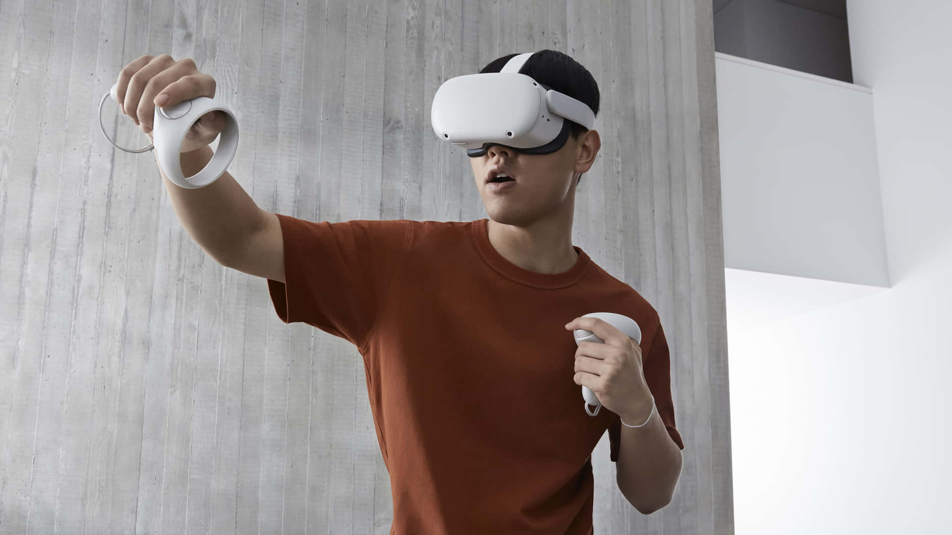 在現代室內環境中使用VR頭戴式顯示器和控制器的人。