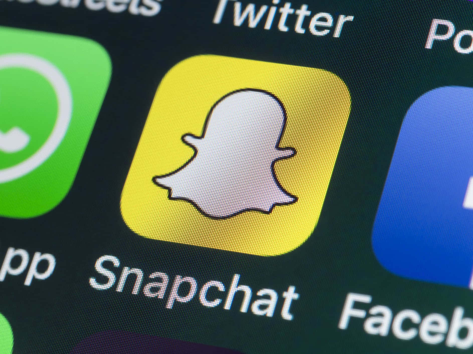 智能手機主屏幕上的Snapchat應用程式圖標及相鄰的社交媒體應用程式。