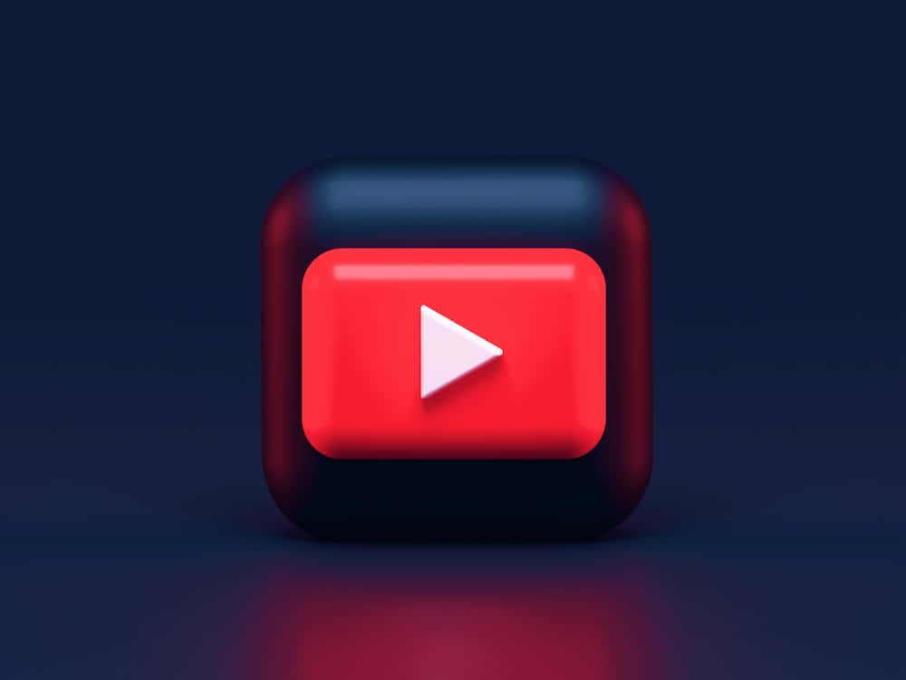 在YouTube上創作並與世界分享你的影片內容 壁紙 — 一個帶有紅色和黑色光芒的亮面3D渲染YouTube播放按鈕圖標，背景為深藍色。