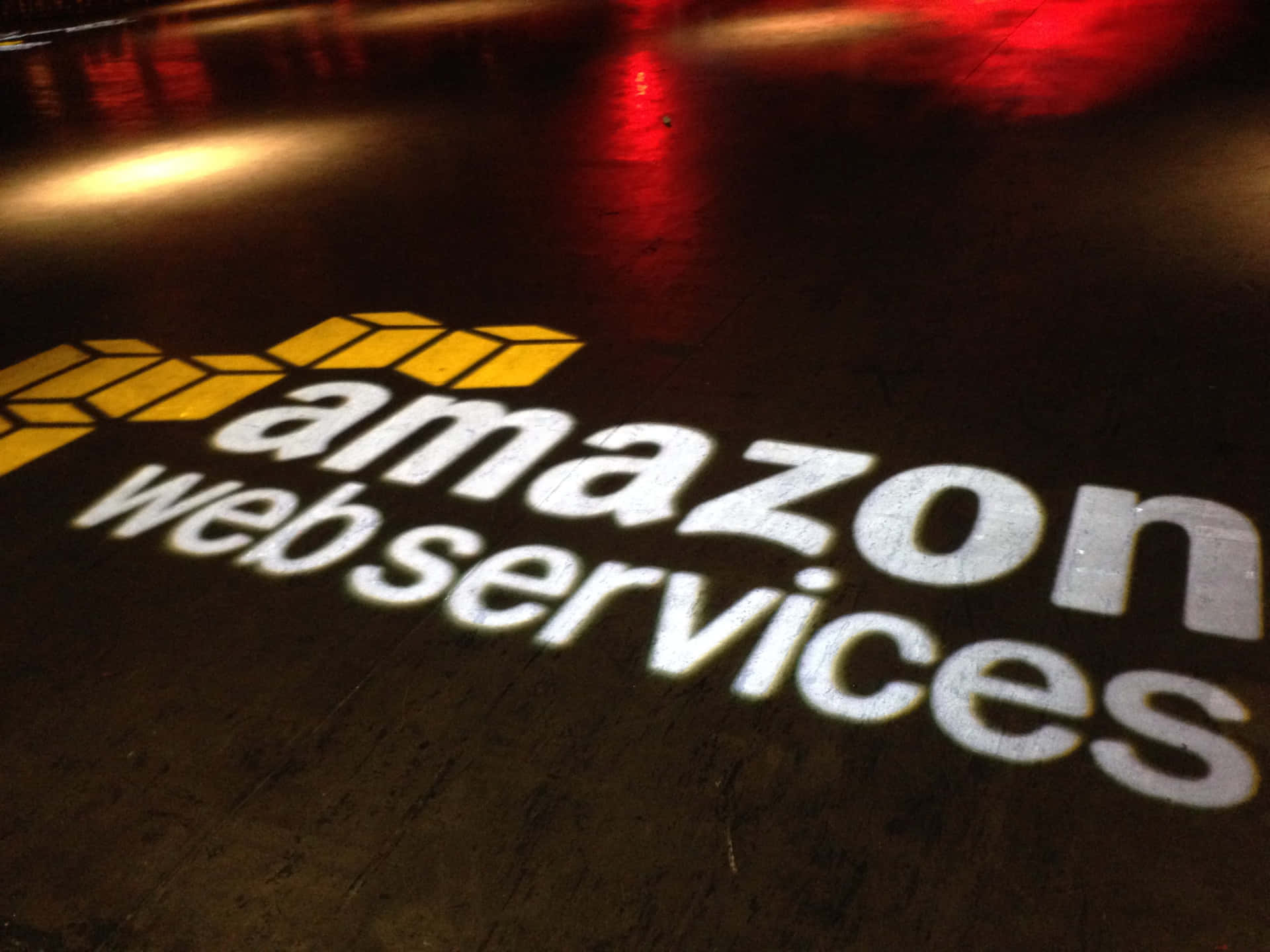 夜間投射在深色地板上的 Amazon Web Services 標誌。
