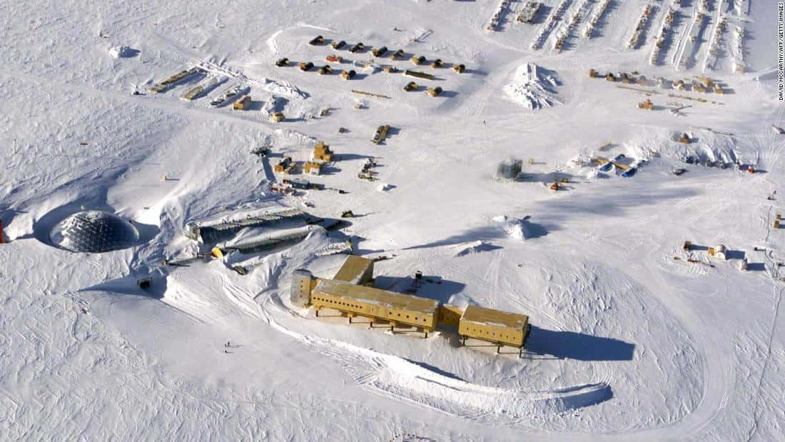 南極研究站，黃色建築物和穹頂位於白雪覆蓋的冰面上。