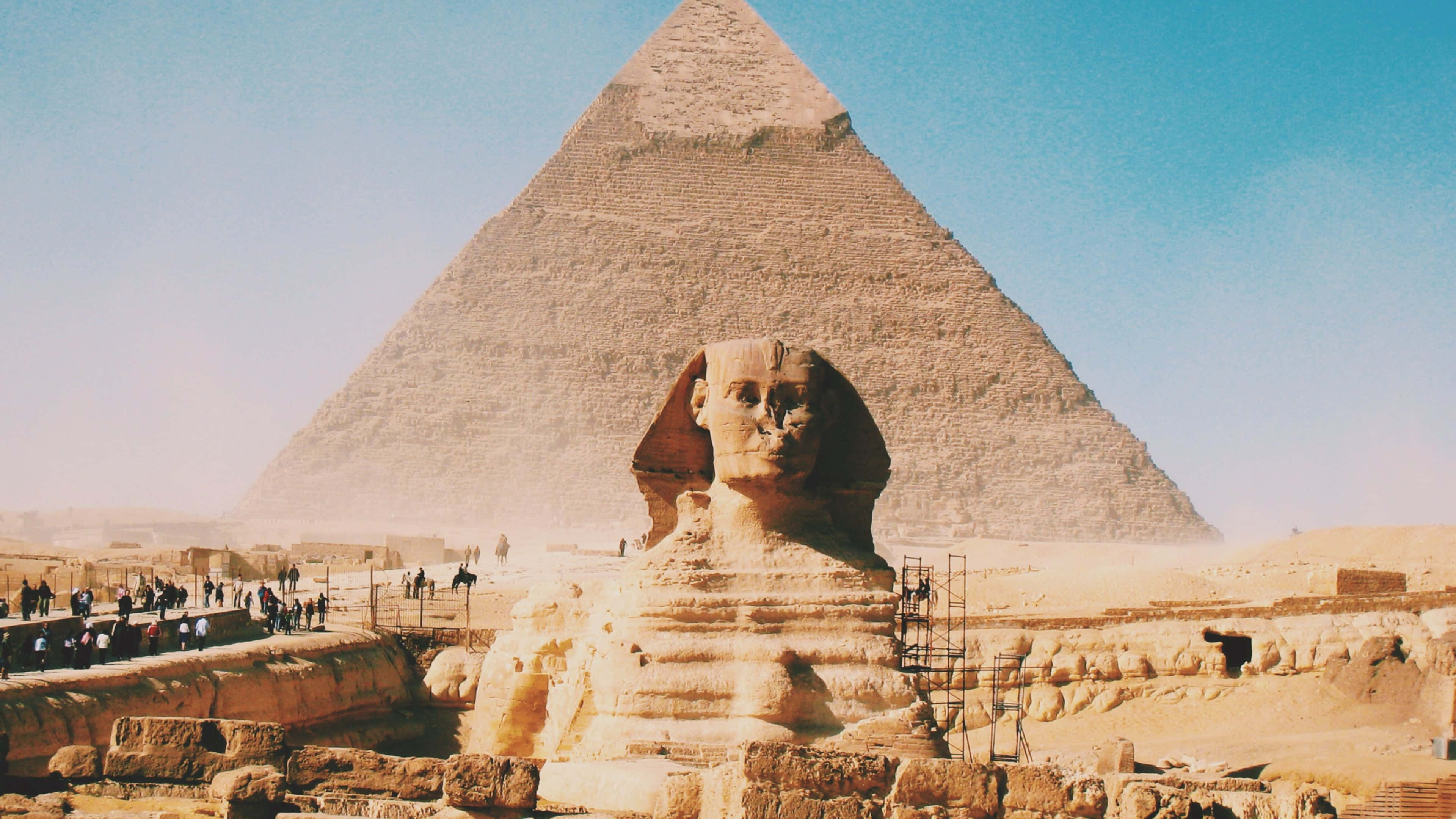 Ancient Egypt 桌布 壁紙 — 在埃及沙漠清澈的藍天下，大獅身人面像守衛在大金字塔前。