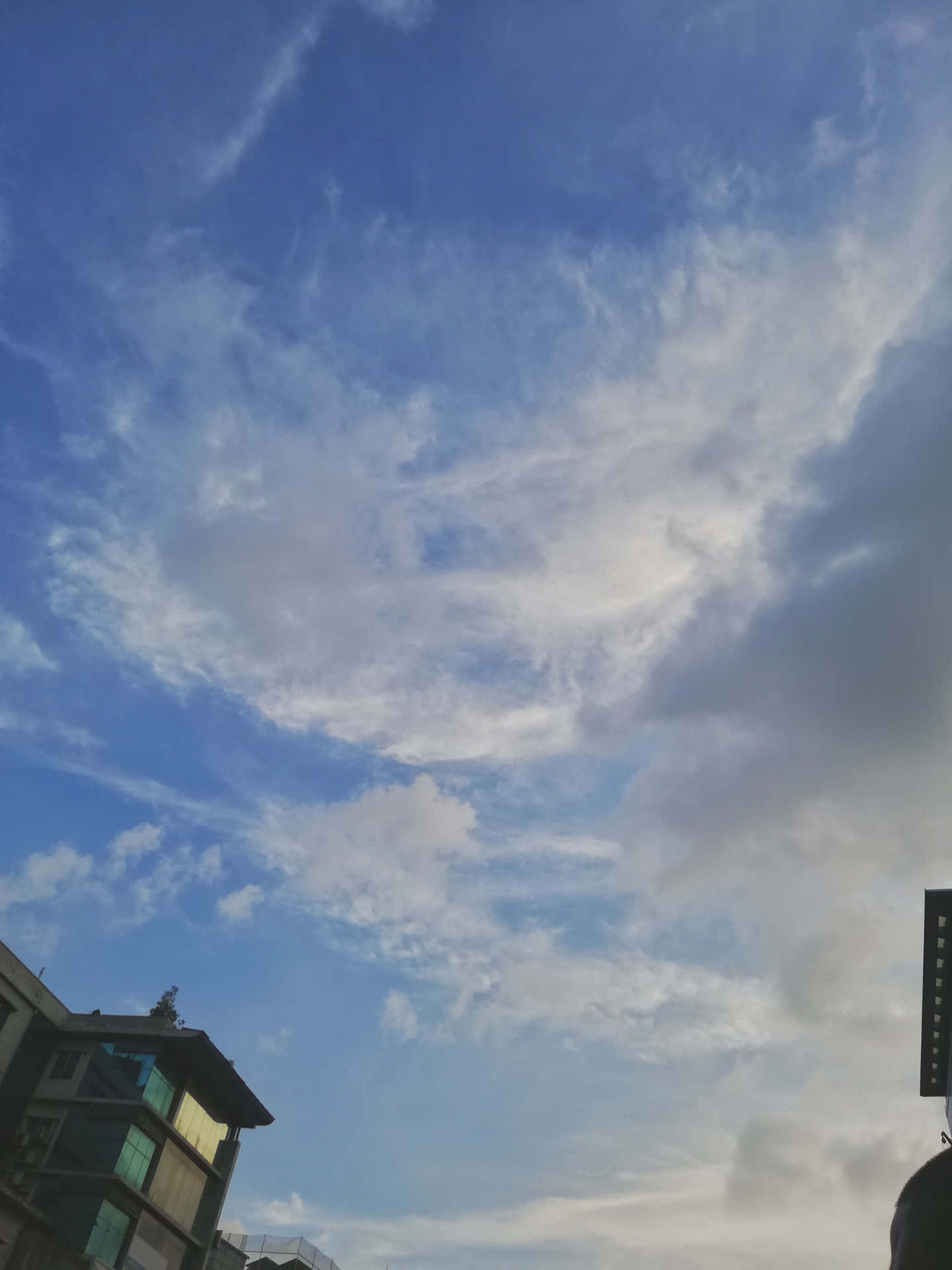 現代建築上方有輕柔白雲的黃昏天空