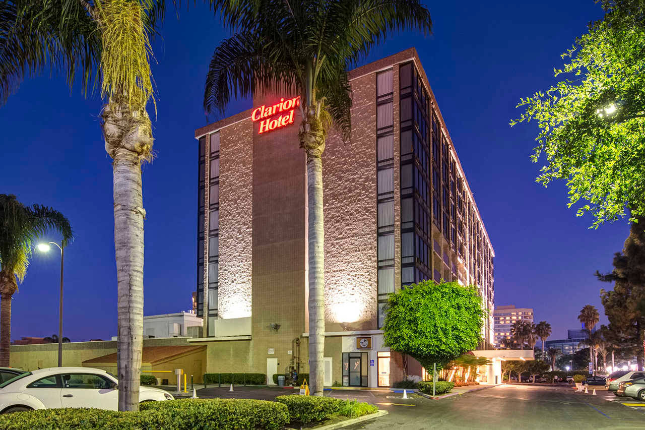 夜晚的 Clarion Hotel，有棕櫚樹和街燈。