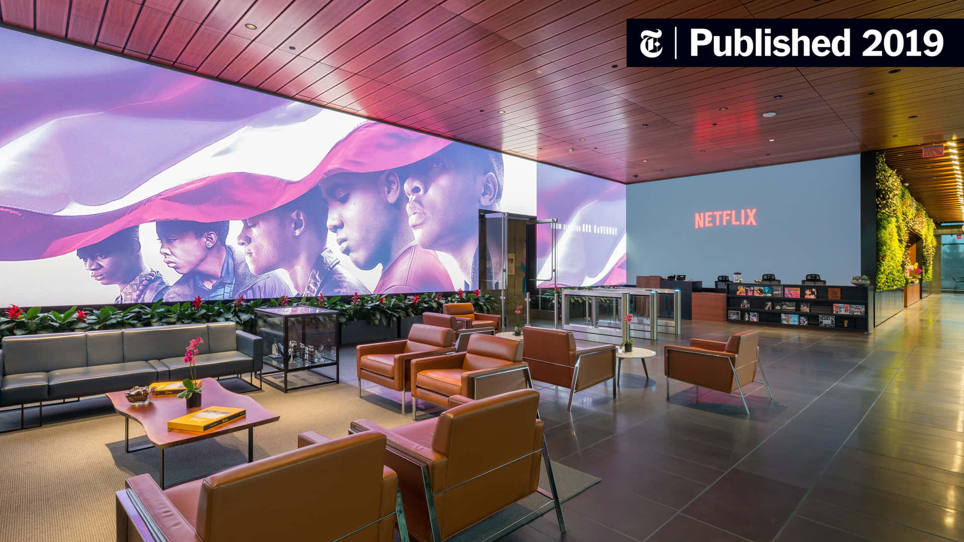 Netflix辦公室大廳，設有橙色椅子和大型壁畫，描繪多元面孔。