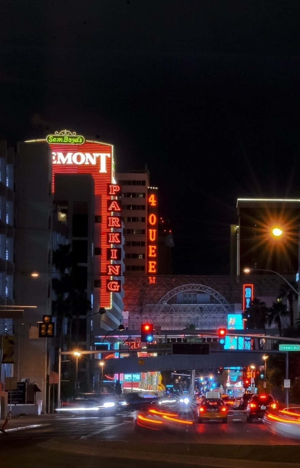 夜晚的街道，霓虹燈閃爍，車燈模糊。