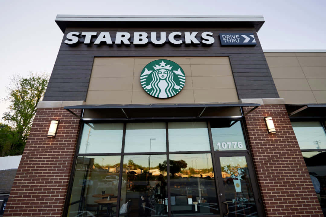 暮色中，Starbucks咖啡店外觀，磚牆和玻璃窗。