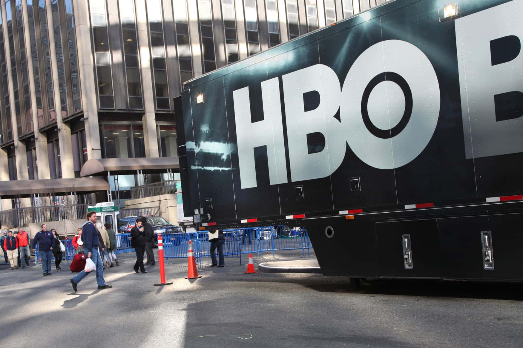 HBO宣傳貨車停泊在城市街道上，有行人經過。