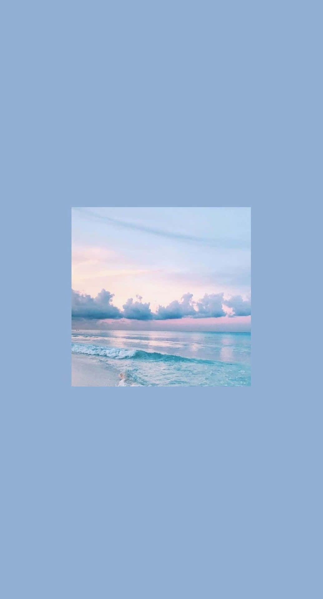 平靜海洋上的粉彩日落，沙灘上輕柔的波浪。