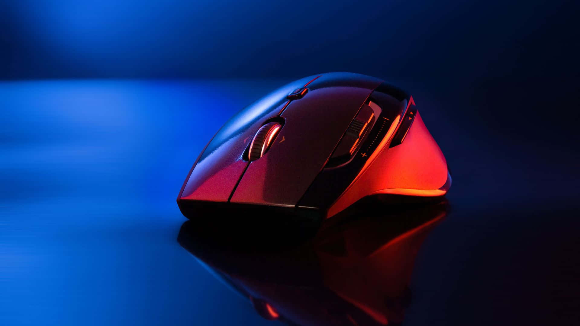 Gaming Mice 桌布 壁紙 — 在工作室拍攝中，一款時尚的遊戲滑鼠在清涼的藍色反光表面上散發出鮮豔的紅色光芒。