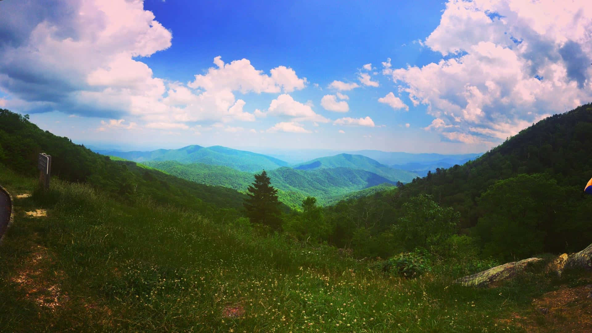 Blue Ridge Mountains 桌布 壁紙 — 在明亮的藍天點綴著蓬鬆白雲下，一片翠綠山脊的廣闊景色。