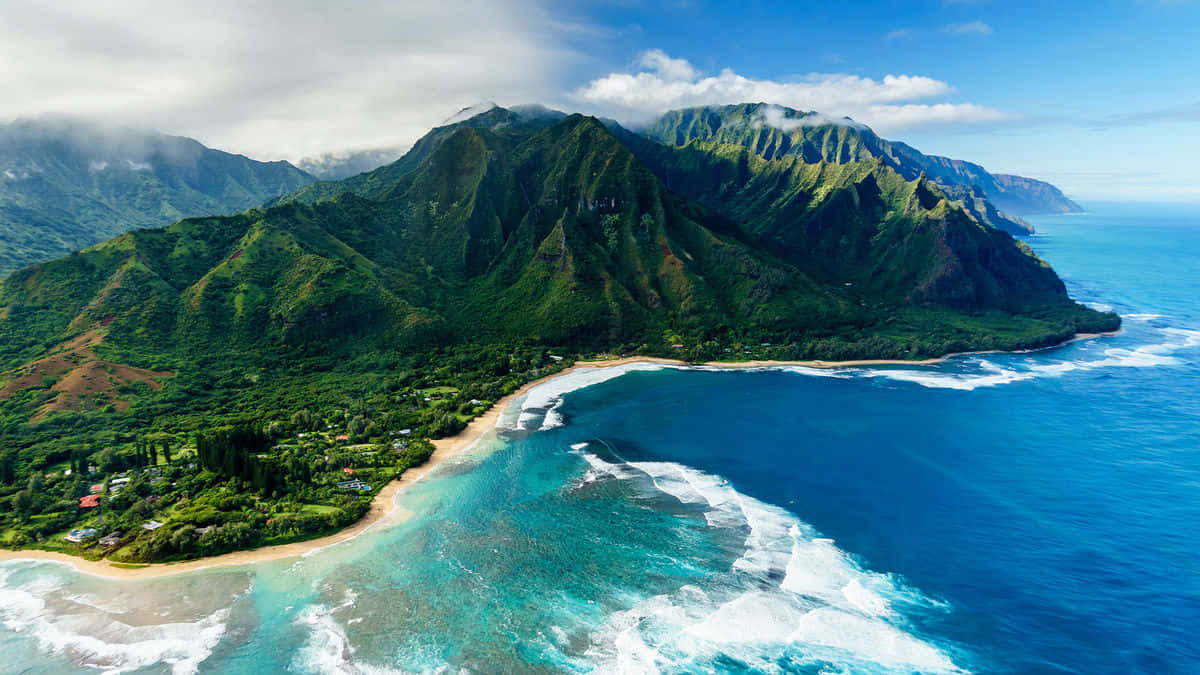 Hawaiian Island 桌布 壁紙 — 在明亮藍天下，沙灘上翠綠山巒與碧綠海浪交匯的鳥瞰圖。