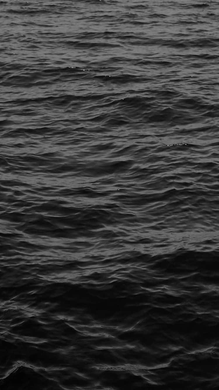 Dark Ocean 桌布 壁紙 — 在昏暗燈光下，帶有細微漣漪和高光的紋理海浪的黑白特寫。