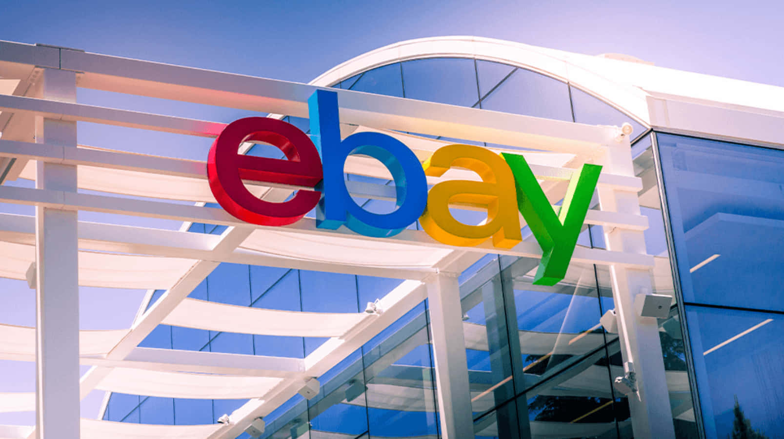 晴朗陽光下，現代玻璃建築上的彩色eBay標誌。