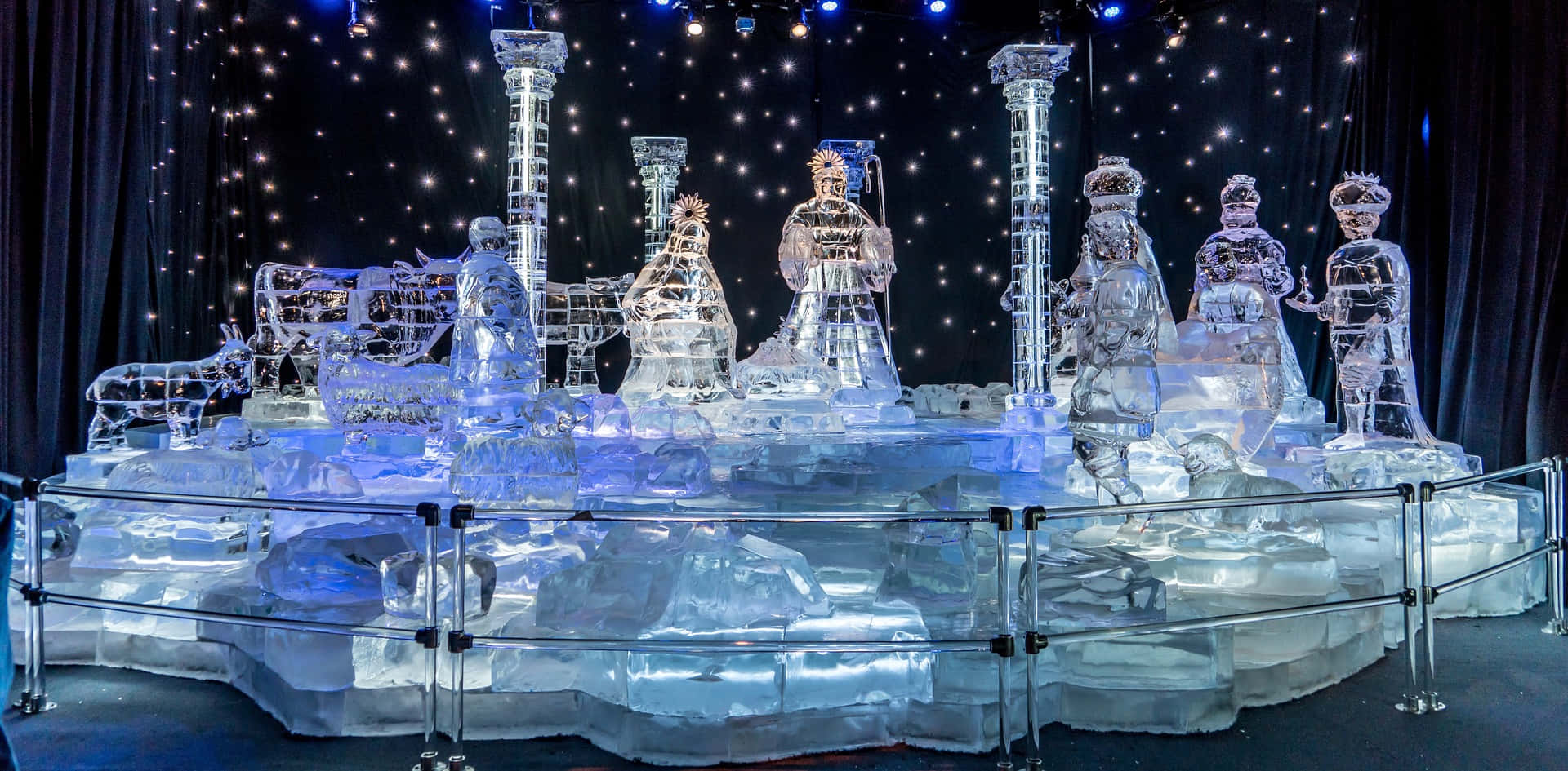 Ice Sculpture 桌布 壁紙 — 在星空背景下，帶有人物和柱子的耶穌誕生場景的發光冰雕。