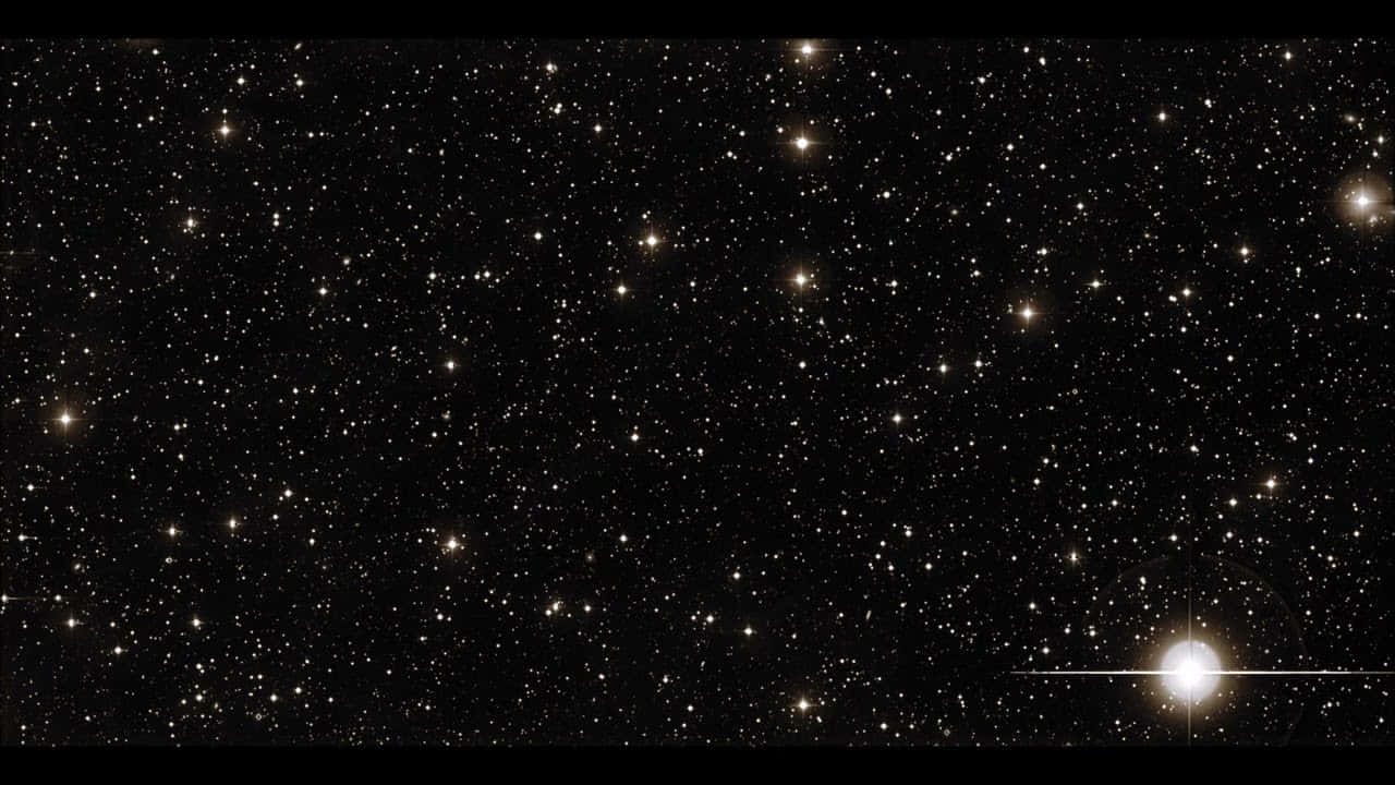 在星際戰爭宇宙中探索銀河 壁紙 — 廣闊的星場，有無數閃爍的星星和一個在右下角發光的明亮天體。