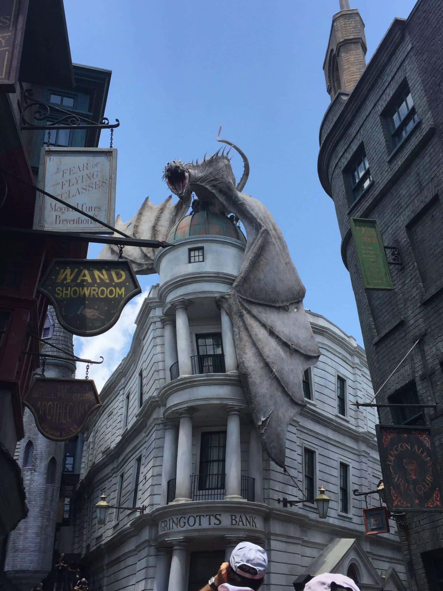 Wizarding World 桌布 壁紙 — 在晴朗的藍天下，一條巨大的龍雕像聳立在斜角巷的古靈閣銀行上方。