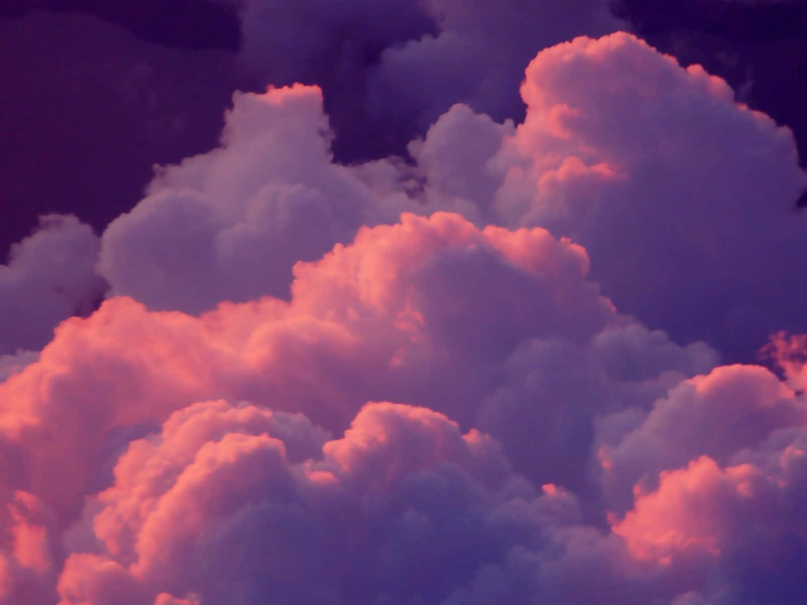 Cloud Aesthetic 桌布 壁紙 — 在暮色天空的映襯下，豐盈的雲朵散發出火紅的粉紅色和深紫色色調。