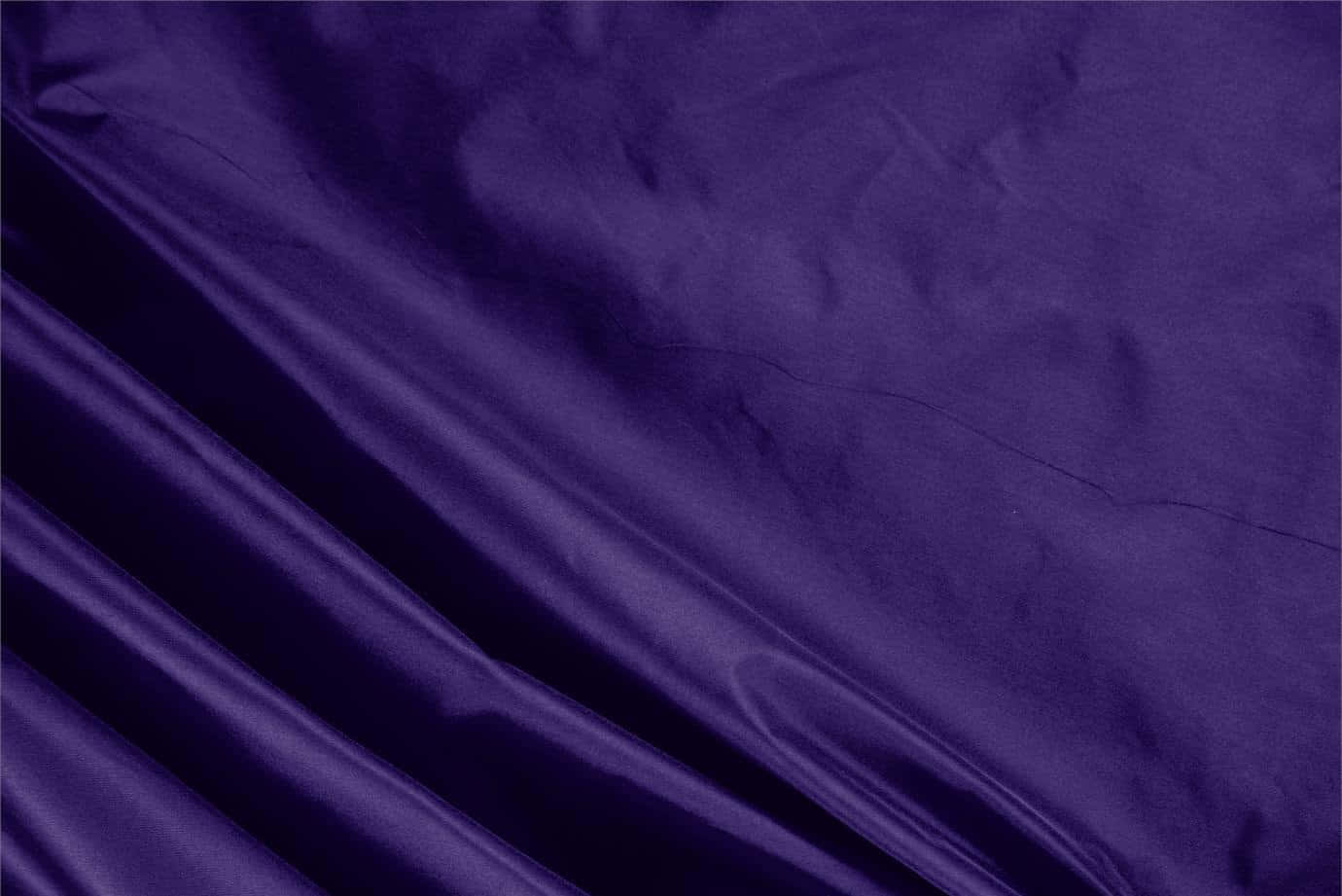Purple Silk 桌布 壁紙 — 在柔和光線下，帶有光滑皺褶和微妙光澤的濃郁深紫色緞面布料。