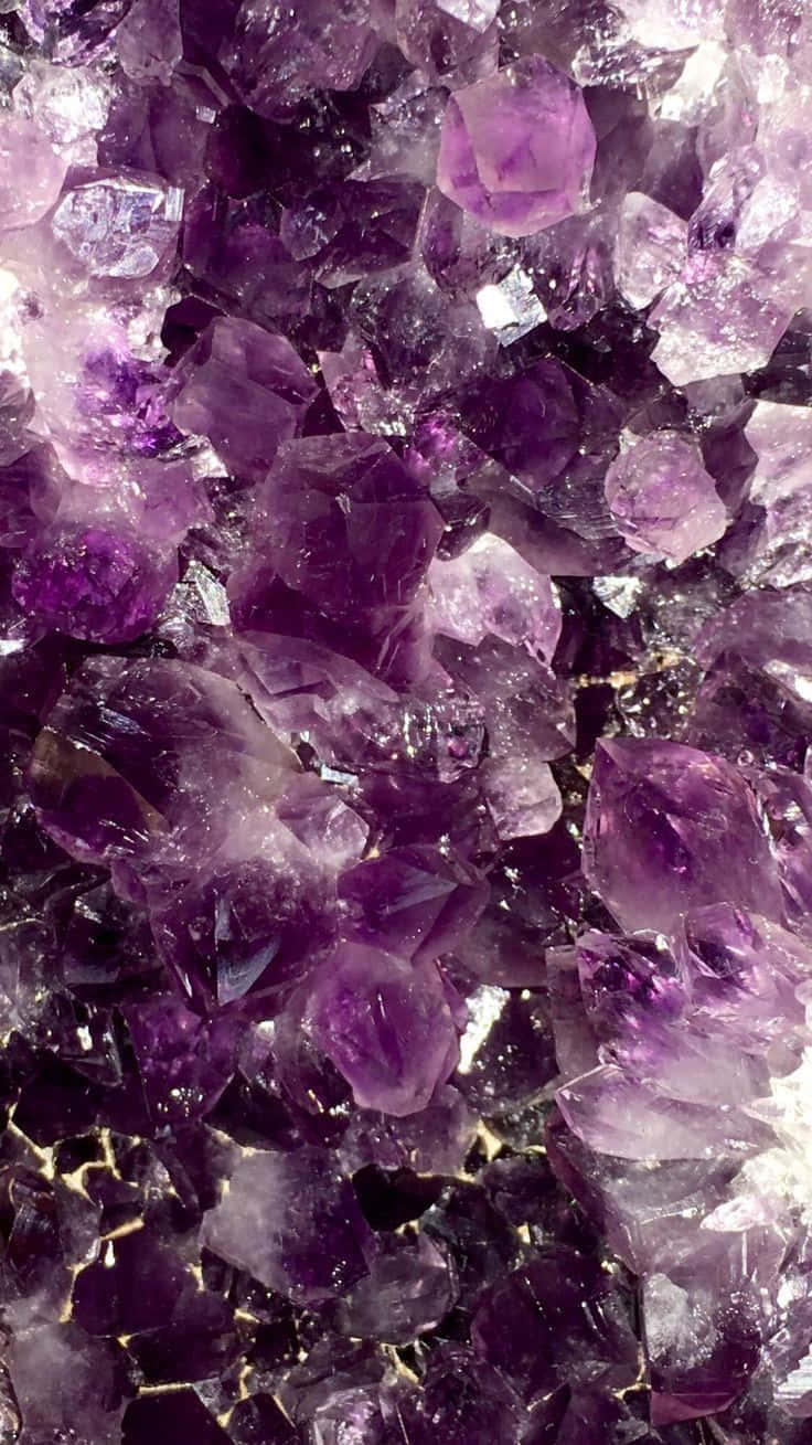Amethyst 桌布 壁紙 — 在柔和光線下閃閃發光的紫色紫水晶晶體特寫，帶有金色紋理。