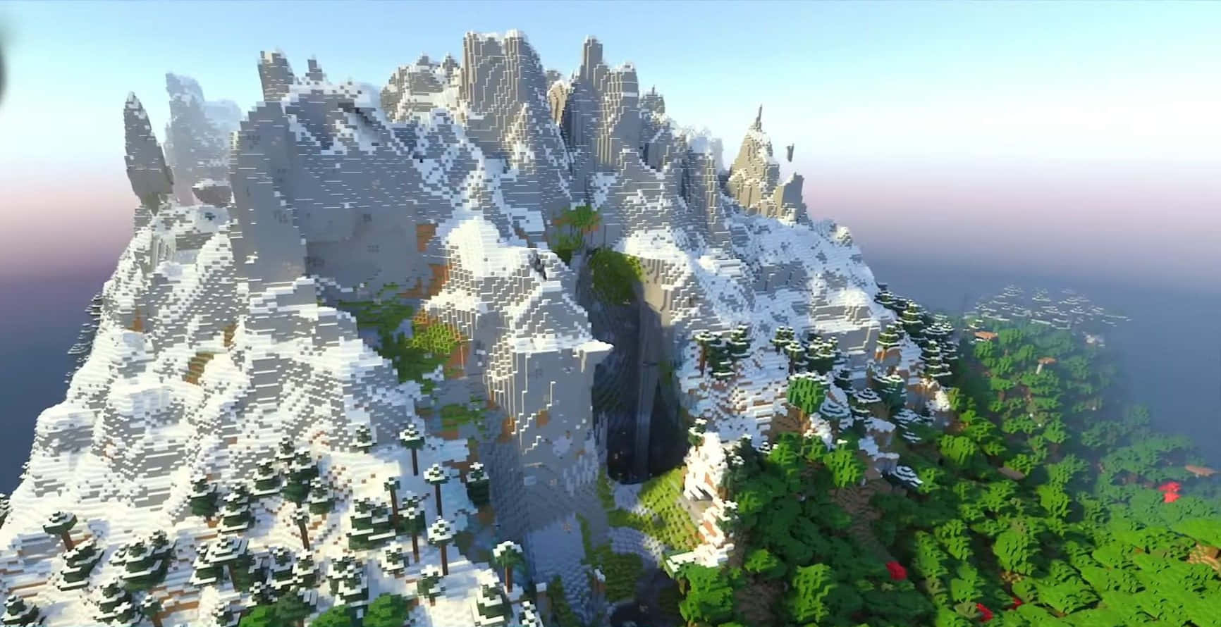 Minecraft Bedrock Edition 桌布 壁紙 — 在柔和嘅日出天空下，一座高聳嘅雪山山脈，山腳有像素化嘅方塊同茂密嘅綠色森林。