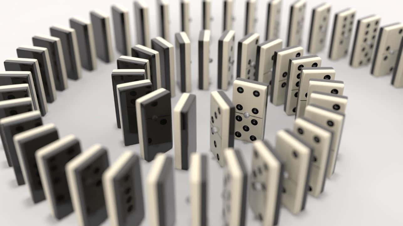 Domino 桌布 壁紙 — 在極簡工作室環境中，多米諾骨牌呈圓形排列，即將倒下。