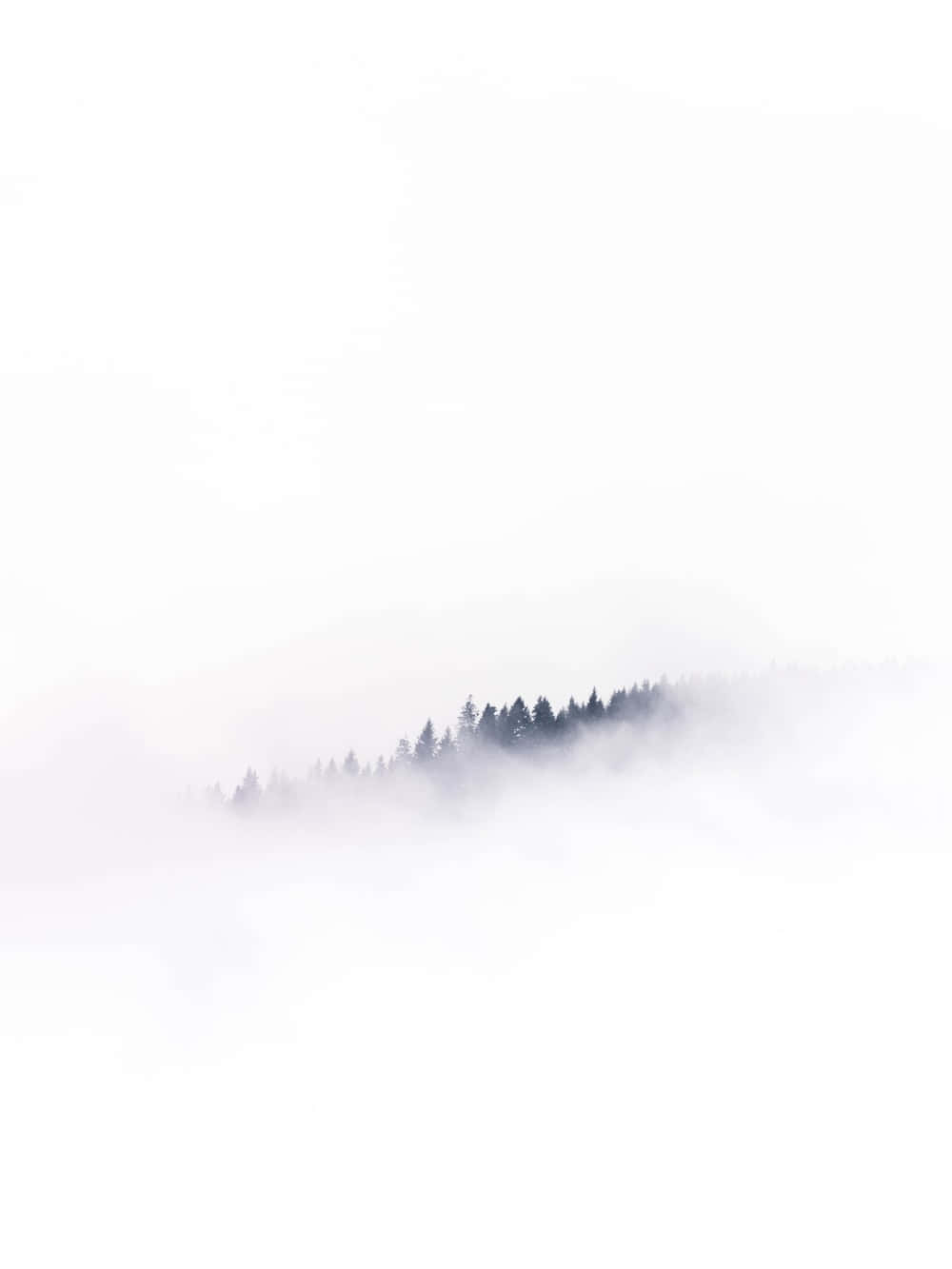 Minimalist Phone 桌布 壁紙 — 在極簡的山景中，一道寧靜的森林山脊從柔和的薄霧中浮現，映襯著蒼白的天空。