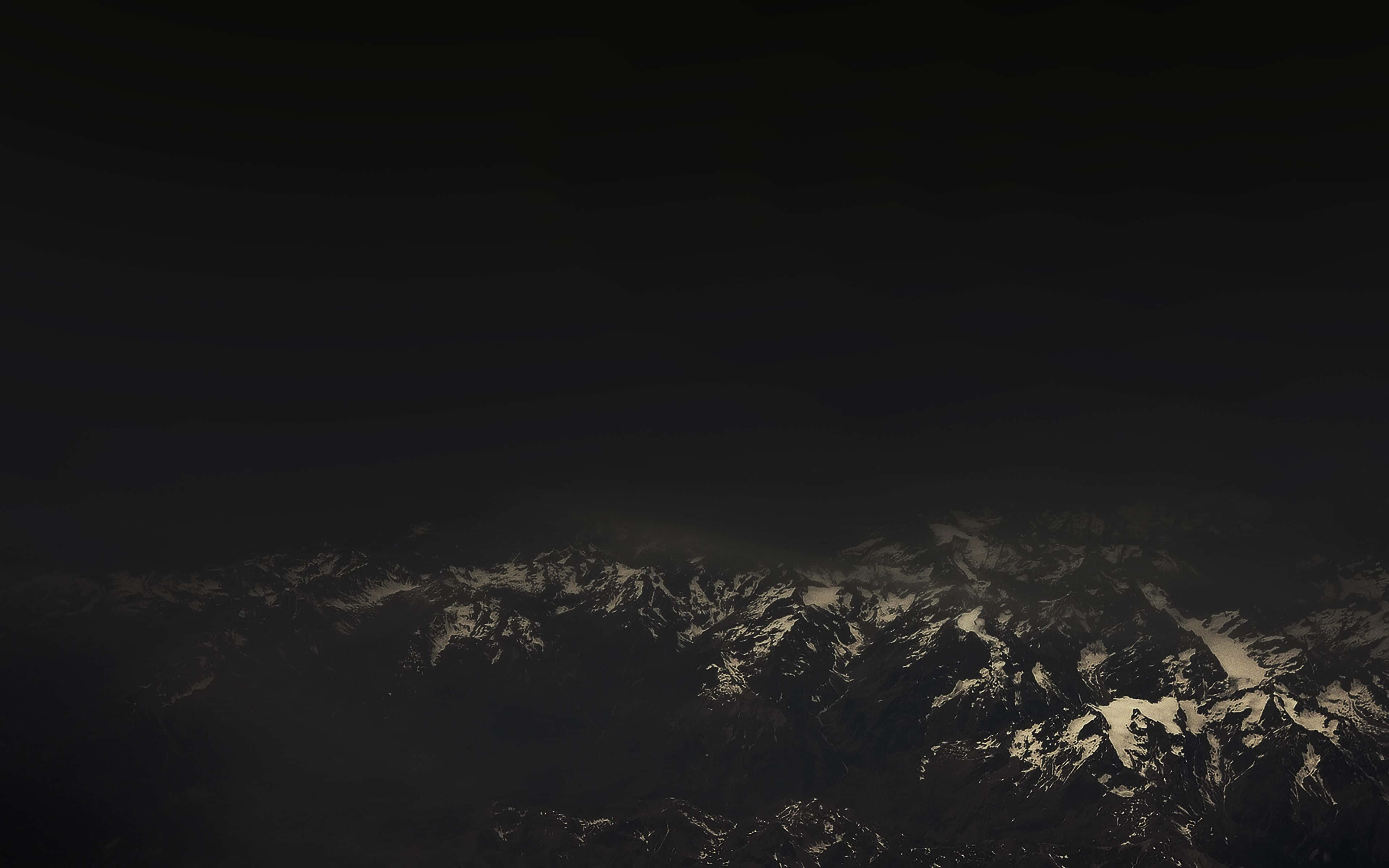 Dark Mountain 桌布 壁紙 — 在沉重的夜空下，幾乎看不見的雪山暗色山脈。