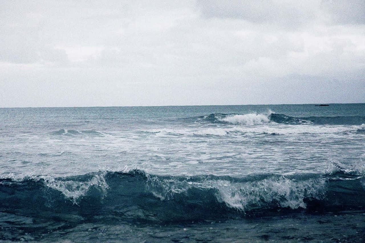 多雲的日子，海浪在海邊拍打。