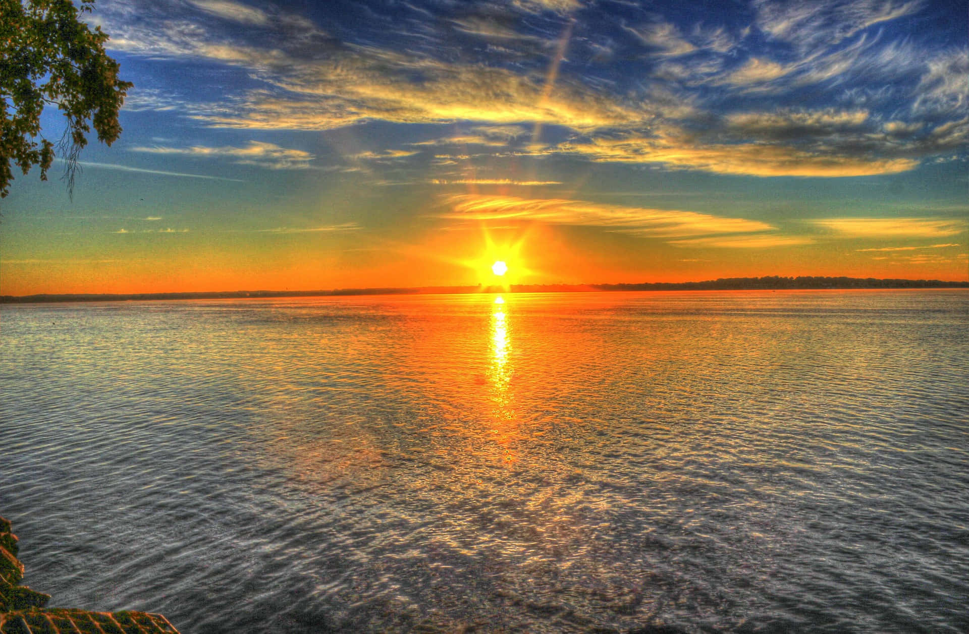 平靜湖面上的夕陽，帶有鮮豔的橙色和藍色天空倒影