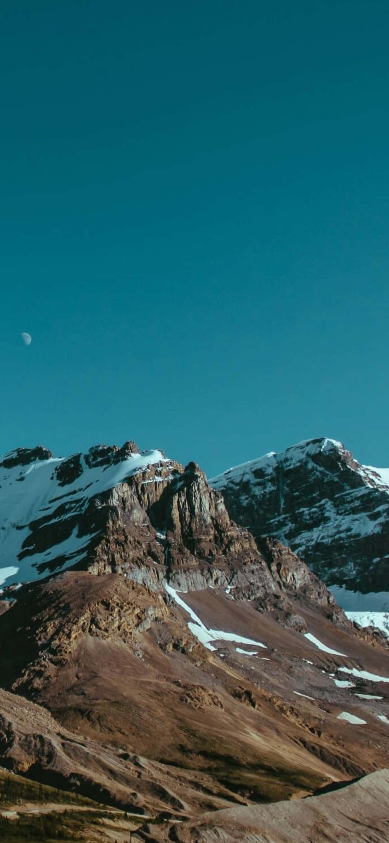 Mountain iPhone 桌布 壁紙 — 在深藍綠色天空下，新月可見的雄偉雪山山脈。