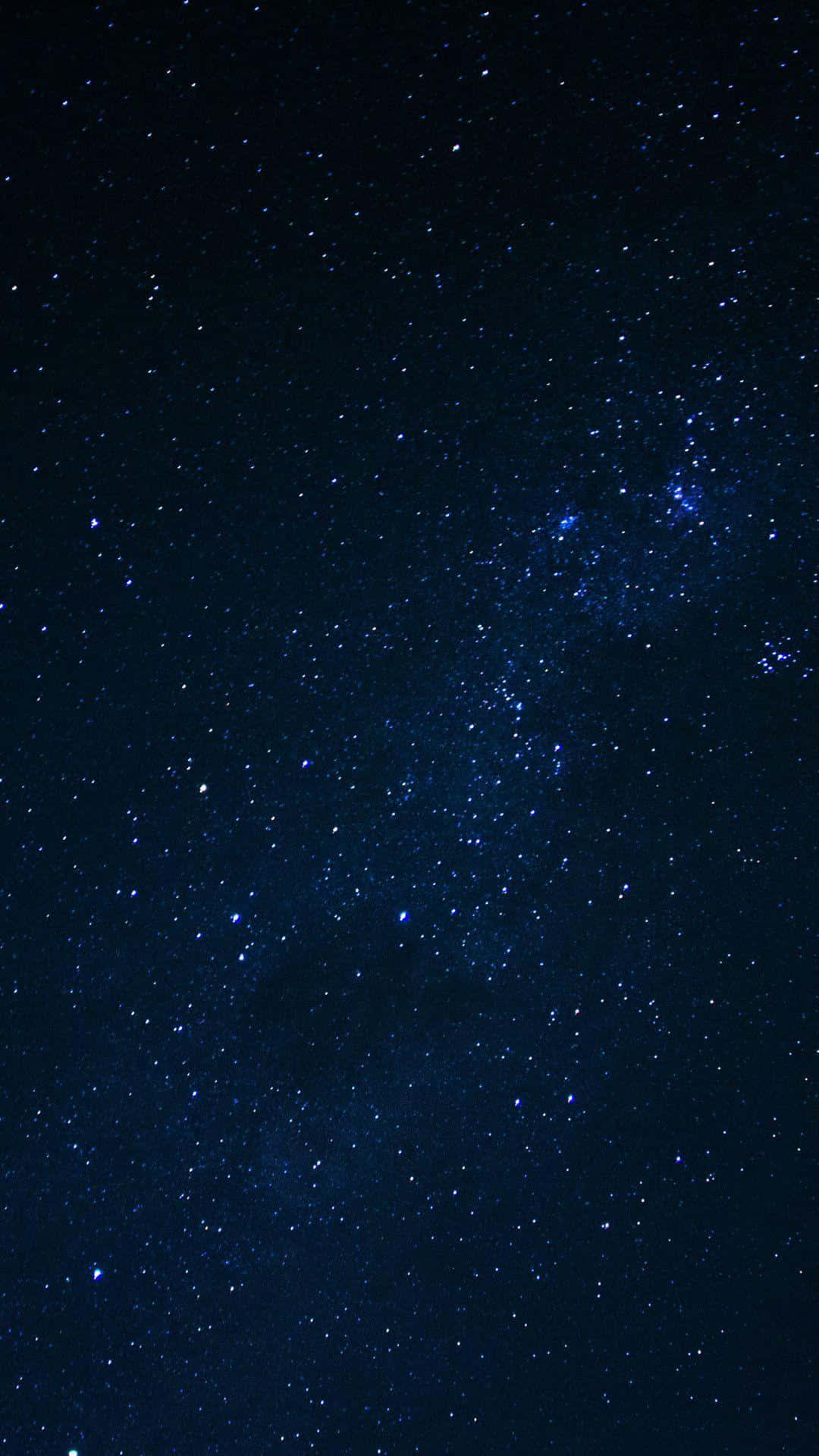 深色手機 桌布 壁紙 — 在深靛藍色夜空下，銀河系閃爍著無數星辰的壯麗景色。