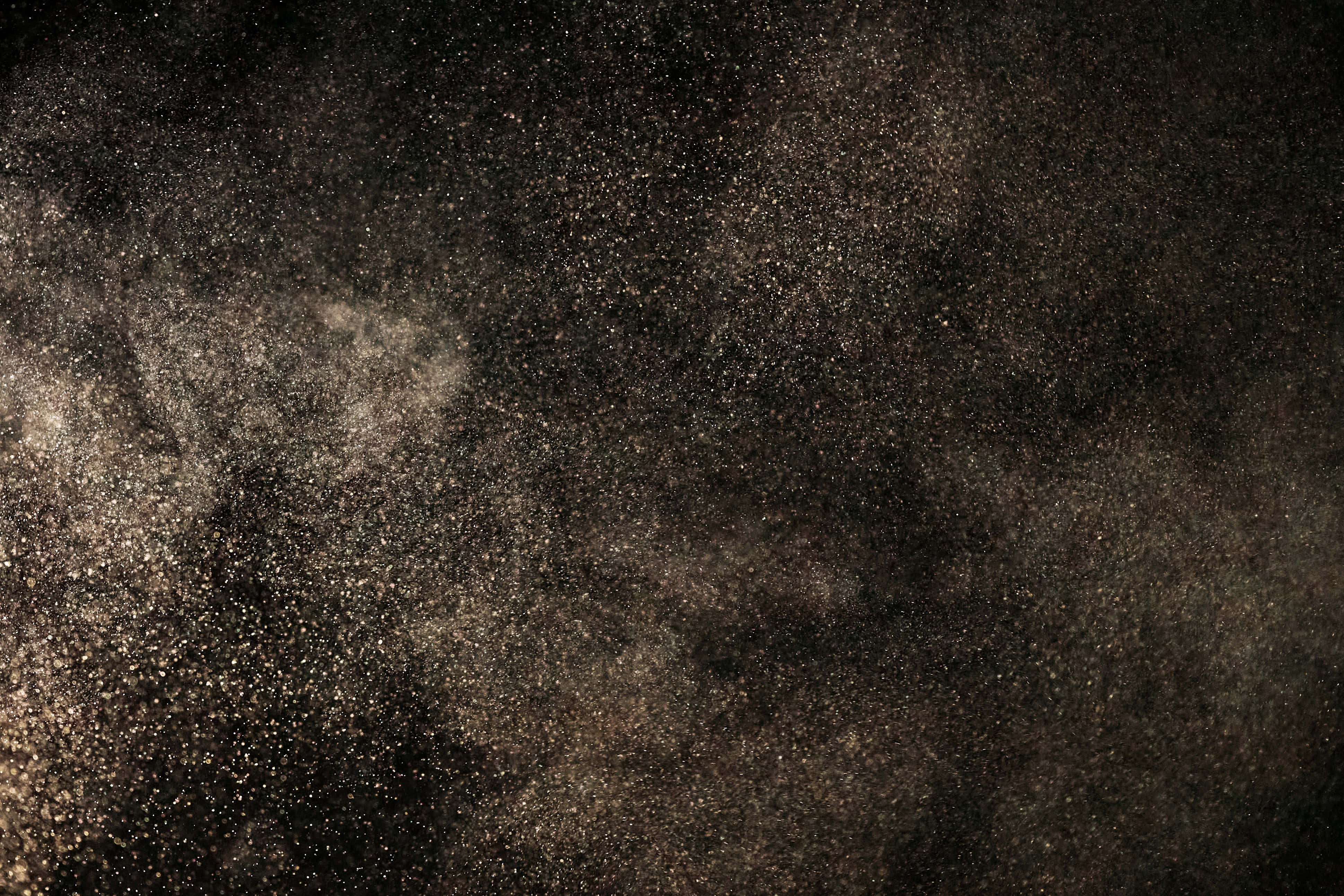 Dust 桌布 壁紙 — 在深黑色背景上懸浮的金色塵埃粒子的戲劇性爆炸。