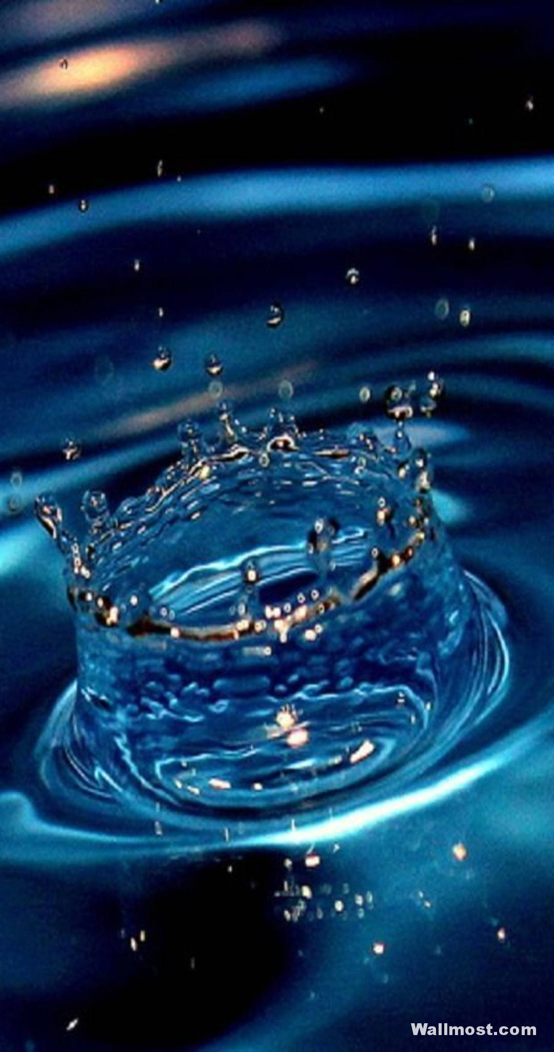 水 桌布 壁紙 — 在溫暖光線下，深藍色水的冰凍飛濺在漣漪表面上方形成一個水滴皇冠。