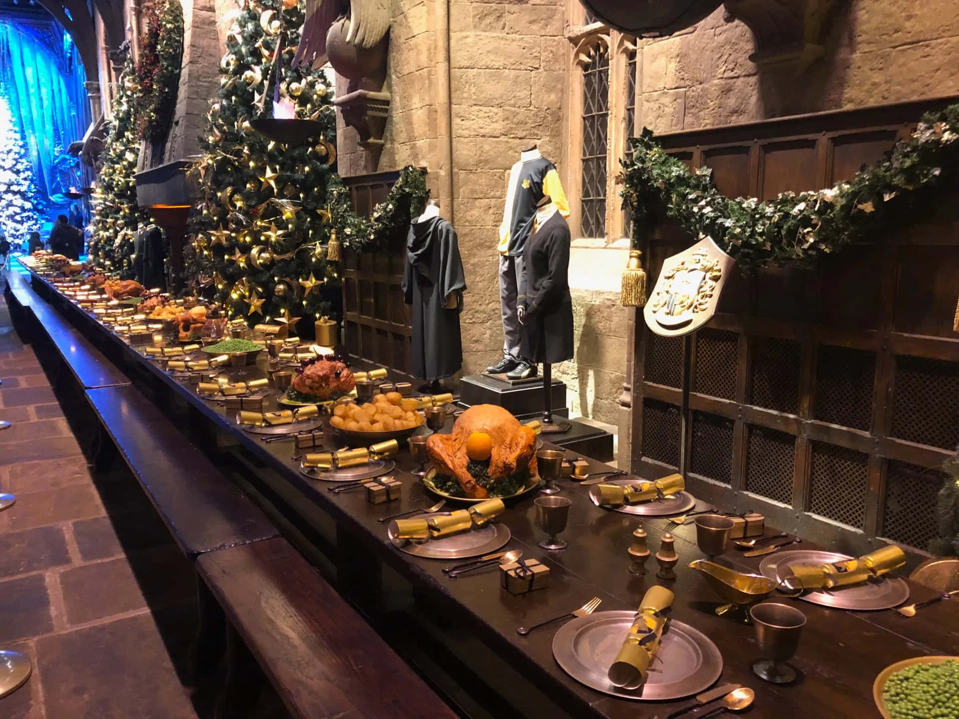 Harry Potter Christmas 桌布 壁紙 — 在溫暖燭光下，霍格華茲大禮堂的盛大宴會桌上擺滿了烤火雞、金色餅乾和節日裝飾。