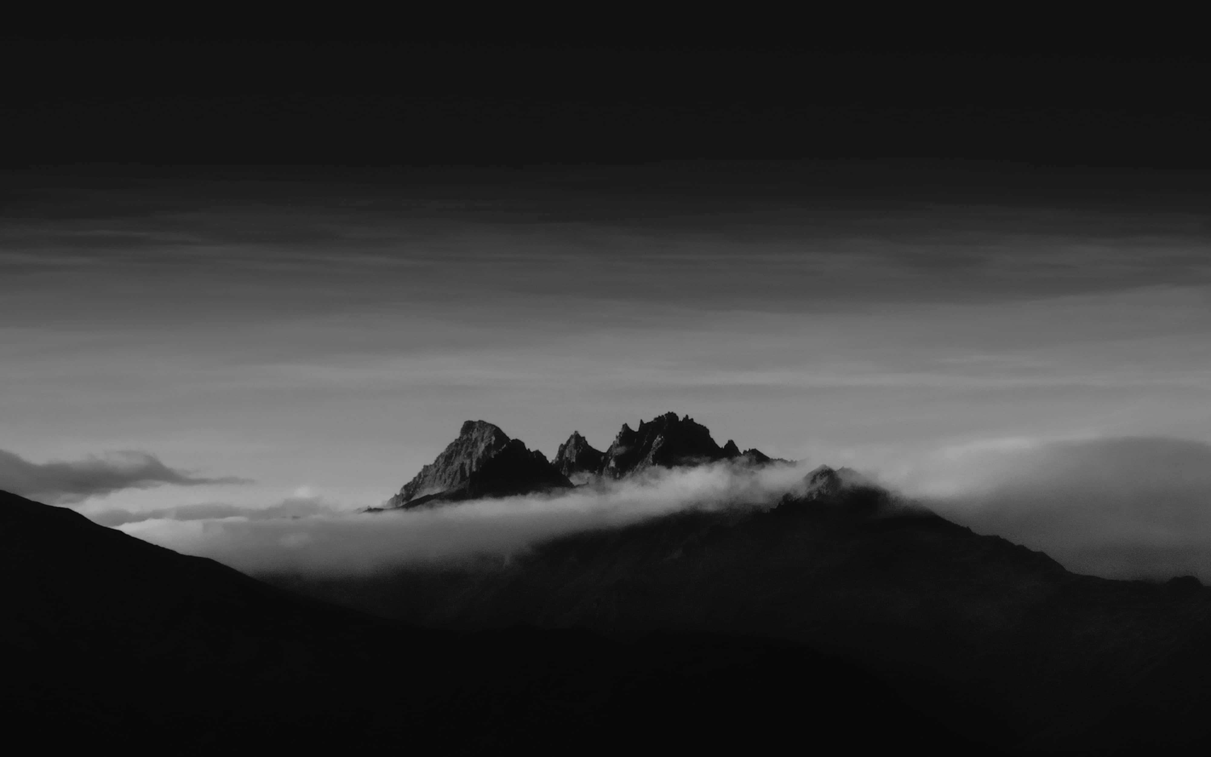 Dark Mountain 桌布 壁紙 — 在漸變天空下，一座黑白分明的山峰刺穿雲海。