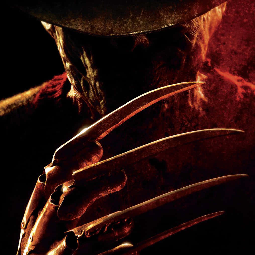 Freddy Krueger 桌布 壁紙 — 在熾熱紅光下，佛萊迪·克魯格燒焦的臉龐和標誌性利刃手套的威脅性特寫。