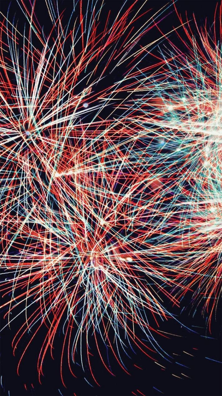 色彩繽紛的煙火在黑暗的夜空中爆發出紅、白、藍色的條紋。